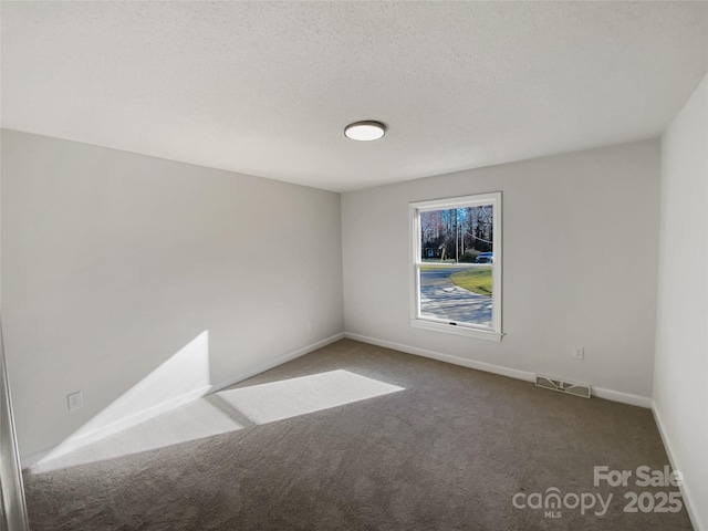 empty room featuring baseboards, a textured ceiling, visible vents, and carpet flooring