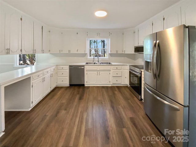 kitchen with stainless steel appliances, white cabinets, light countertops, and a sink