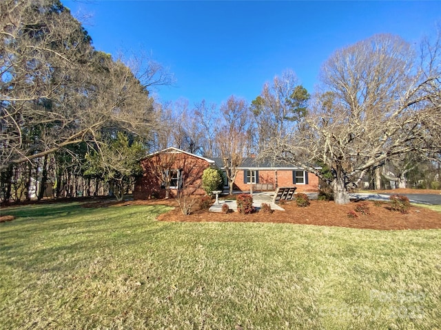 view of front of property featuring a front lawn and brick siding