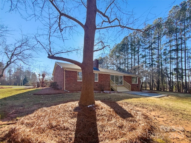 view of side of home with a yard and brick siding