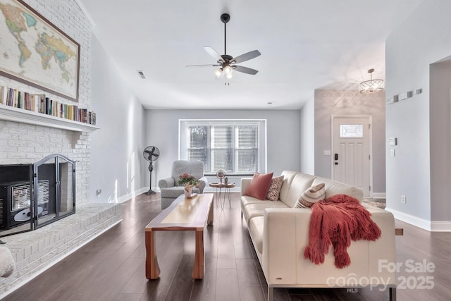 living room featuring plenty of natural light, a brick fireplace, and wood finished floors