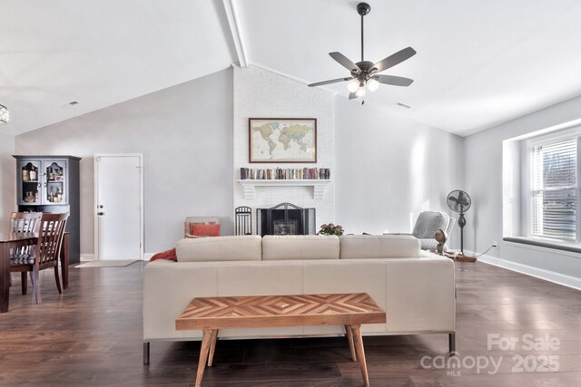 living area featuring dark wood-style floors, a fireplace, vaulted ceiling with beams, and visible vents