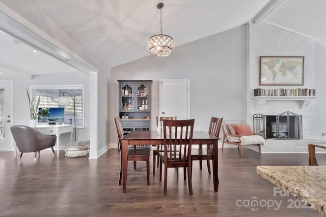 dining area with vaulted ceiling with beams, a notable chandelier, a fireplace, baseboards, and dark wood-style floors