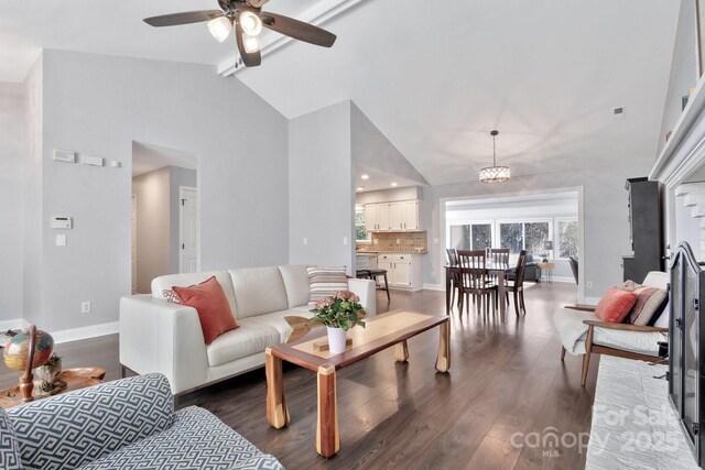 living area featuring a ceiling fan, dark wood finished floors, high vaulted ceiling, and baseboards