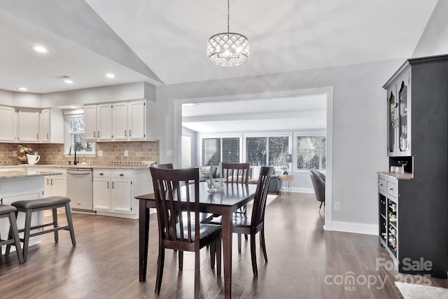 dining space featuring a wealth of natural light, baseboards, and dark wood-style flooring