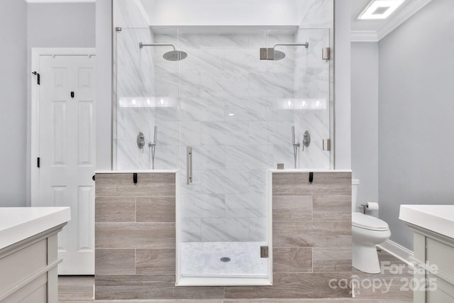 bathroom with toilet, a shower stall, crown molding, and vanity