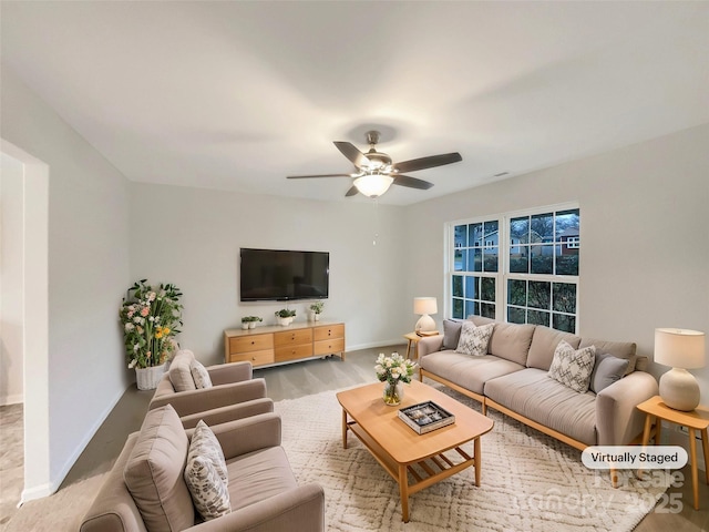 living room with ceiling fan and baseboards