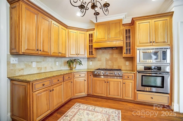 6548 Robin Hollow Dr, Mint Hill, NC 28227 - kitchen featuring light stone countertops, stainless steel gas cooktop, glass insert cabinets, tasteful backsplash, and a chandelier
