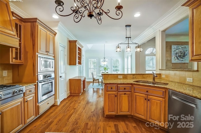 6548 Robin Hollow Dr, Mint Hill, NC 28227 - kitchen with ornamental molding, brown cabinets, appliances with stainless steel finishes, a notable chandelier, and a sink