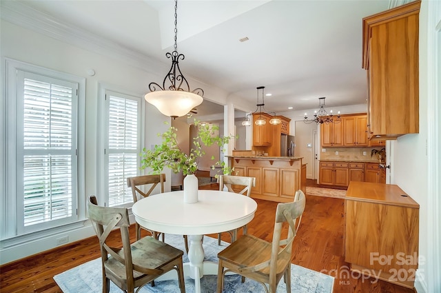 6548 Robin Hollow Dr, Mint Hill, NC 28227 - dining room featuring light wood-type flooring, a notable chandelier, and crown molding