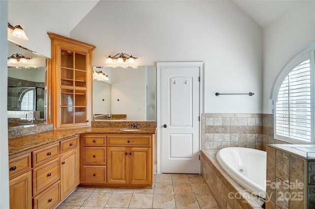 6548 Robin Hollow Dr, Mint Hill, NC 28227 - bathroom with vanity, tiled shower, lofted ceiling, tile patterned flooring, and a garden tub
