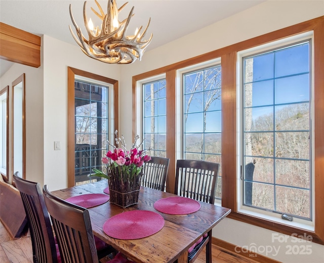 61 Creekside Way Unit G201, Burnsville, NC 28714 - dining area featuring a chandelier, healthy amount of natural light, and light wood finished floors