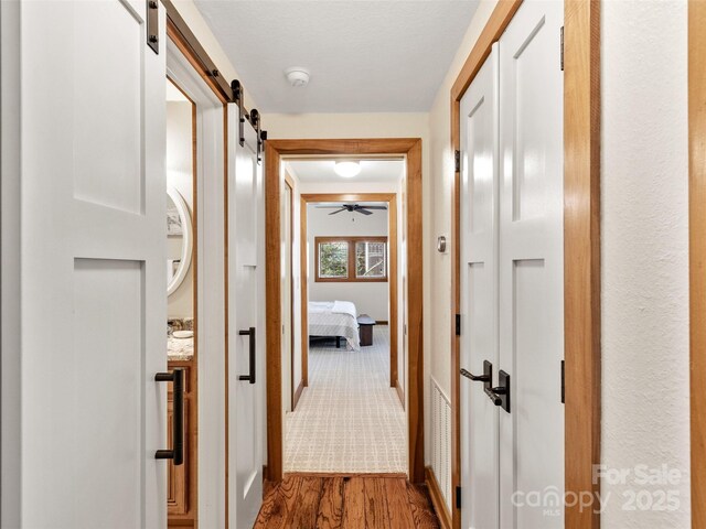 61 Creekside Way Unit G201, Burnsville, NC 28714 - hall featuring a barn door and wood finished floors