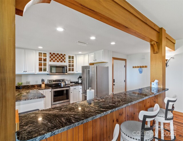 61 Creekside Way Unit G201, Burnsville, NC 28714 - kitchen with stainless steel appliances, a peninsula, dark stone counters, glass insert cabinets, and white cabinets