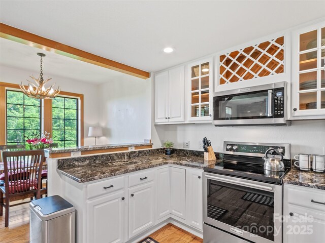 61 Creekside Way Unit G201, Burnsville, NC 28714 - kitchen with appliances with stainless steel finishes, a peninsula, white cabinetry, glass insert cabinets, and recessed lighting