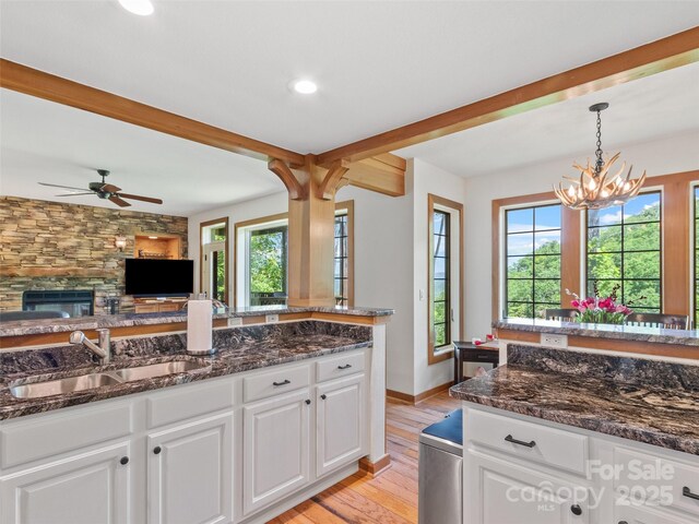61 Creekside Way Unit G201, Burnsville, NC 28714 - kitchen with a sink, light wood-style flooring, white cabinets, hanging light fixtures, and dark stone counters