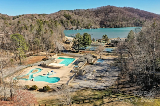 drone / aerial view with a water view and a view of trees