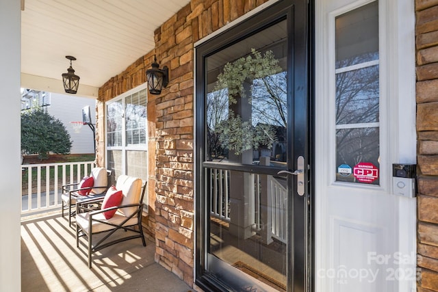 property entrance featuring brick siding and covered porch