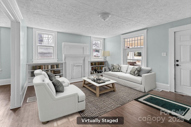 living room featuring baseboards, visible vents, and wood finished floors