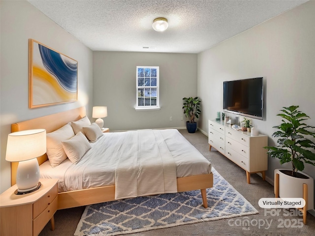 carpeted bedroom with baseboards and a textured ceiling