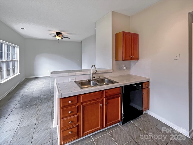 kitchen featuring black dishwasher, a sink, ceiling fan, a peninsula, and baseboards