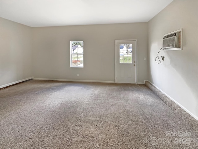 interior space featuring an AC wall unit, carpet, and baseboards