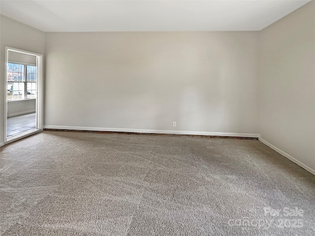 carpeted spare room featuring baseboards