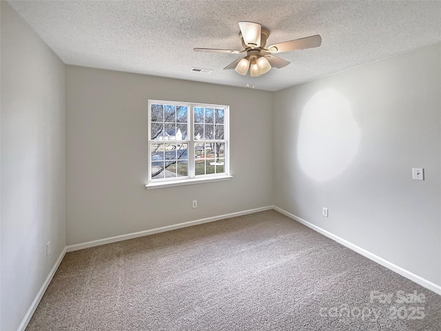 empty room featuring a ceiling fan, baseboards, visible vents, and carpet flooring