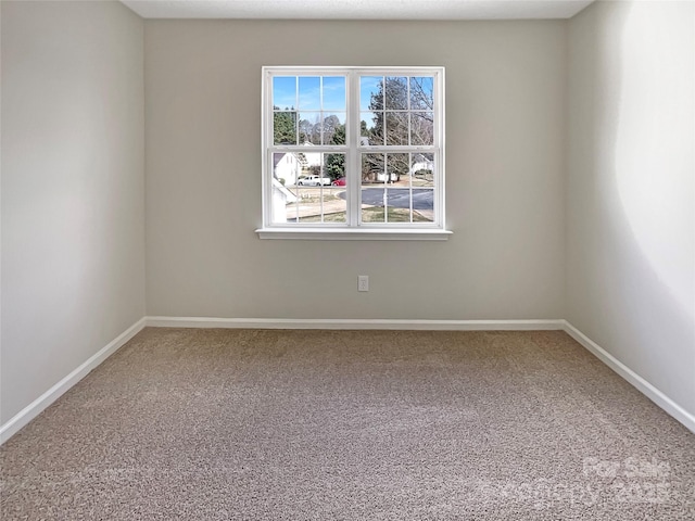 carpeted spare room featuring baseboards