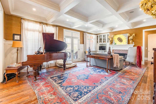 living room featuring beam ceiling, ornamental molding, hardwood / wood-style flooring, coffered ceiling, and french doors