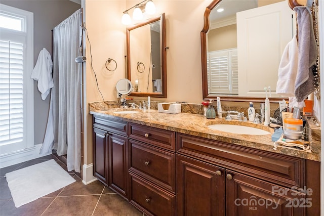 bathroom featuring tile patterned floors, double vanity, and a sink