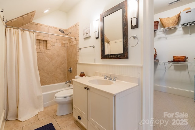 bathroom with vanity, a wainscoted wall, shower / tub combo, tile patterned floors, and toilet