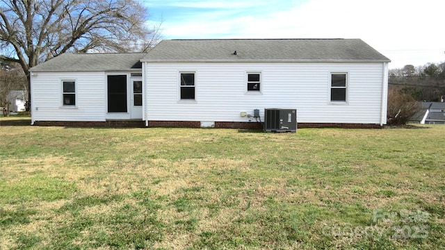 back of house featuring a shingled roof, a yard, and central air condition unit