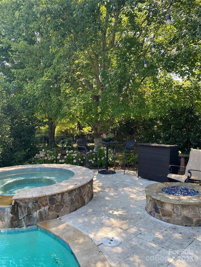 view of swimming pool with an outdoor fire pit, a fenced in pool, an in ground hot tub, fence, and a patio area