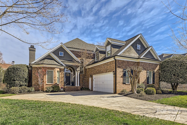 traditional home featuring driveway, a front yard, a chimney, and brick siding