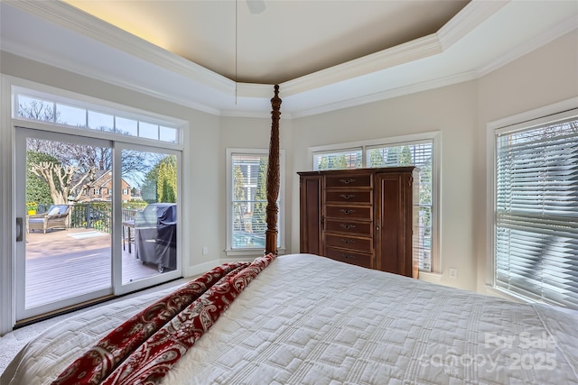 bedroom with crown molding, a raised ceiling, and access to exterior