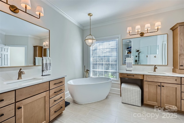 full bath with a freestanding tub, two vanities, a sink, and crown molding