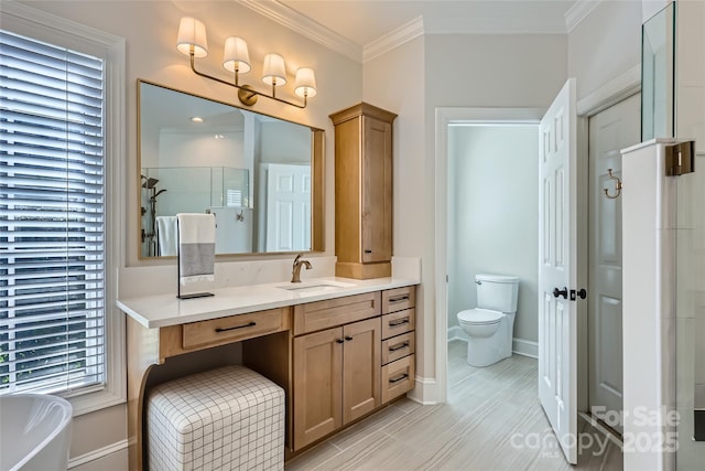 bathroom featuring a freestanding bath, vanity, toilet, and crown molding