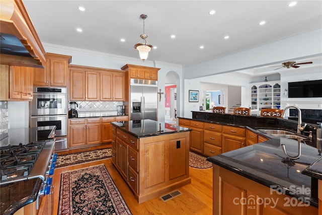 kitchen with visible vents, ceiling fan, a large island with sink, stainless steel appliances, and a sink