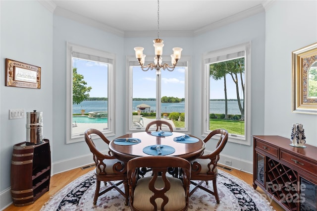 dining space with baseboards, light wood-style floors, an inviting chandelier, and ornamental molding