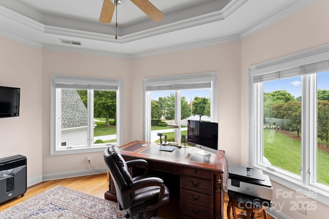 office with a tray ceiling, plenty of natural light, light wood-style floors, and visible vents