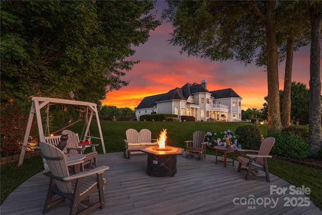 wooden terrace with a yard and an outdoor fire pit