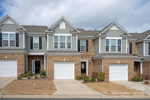 multi unit property featuring a garage, driveway, and brick siding