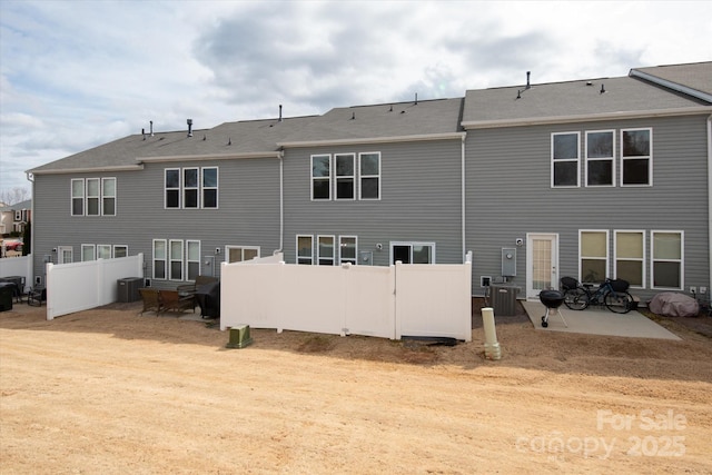 rear view of property with a patio, fence, and central air condition unit