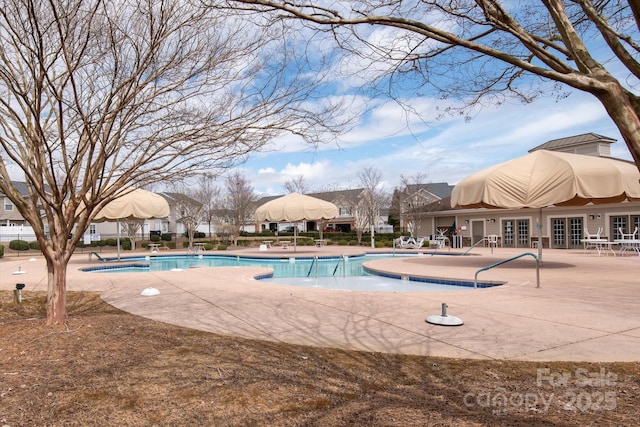 community pool with french doors and a patio area