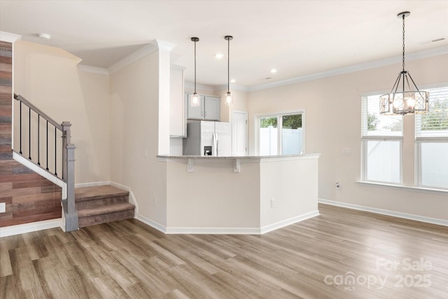 kitchen featuring plenty of natural light, light wood finished floors, and stainless steel fridge with ice dispenser