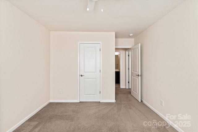 unfurnished bedroom with carpet flooring and baseboards