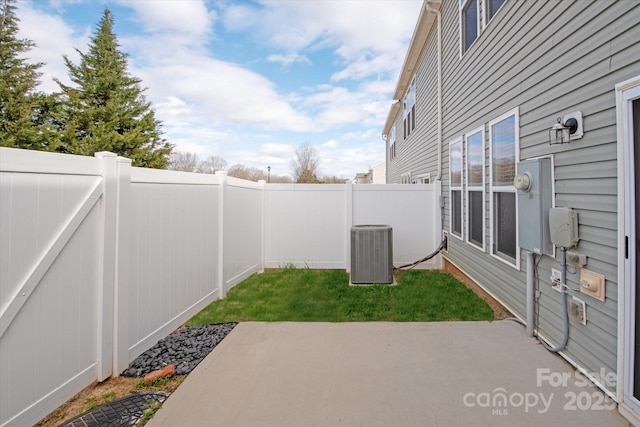 view of yard with a patio area, a fenced backyard, and central AC unit