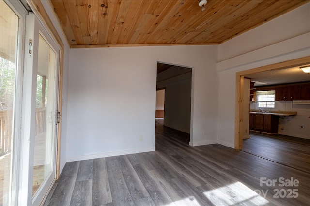 interior space with wooden ceiling, a sink, baseboards, and wood finished floors