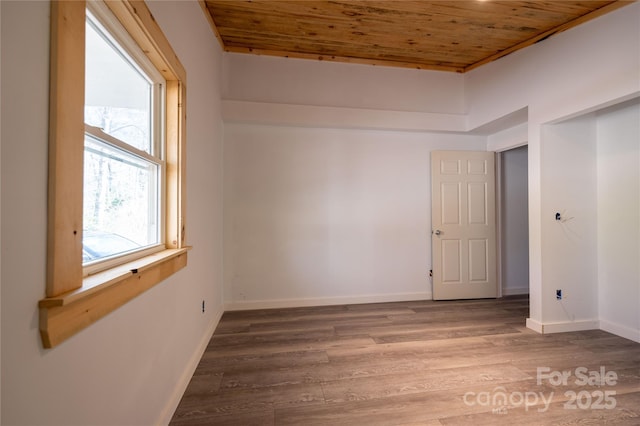 spare room with wood ceiling, baseboards, and wood finished floors